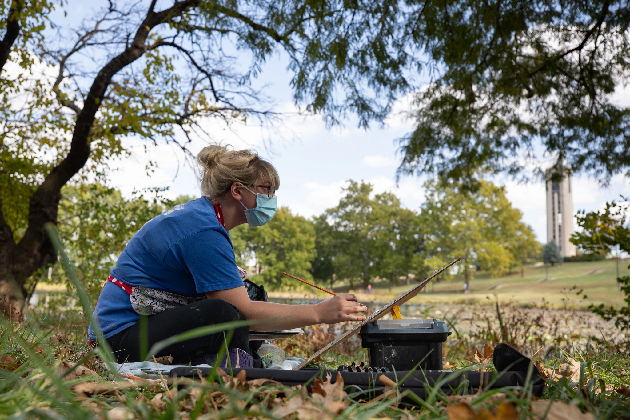 A lady painting on grass