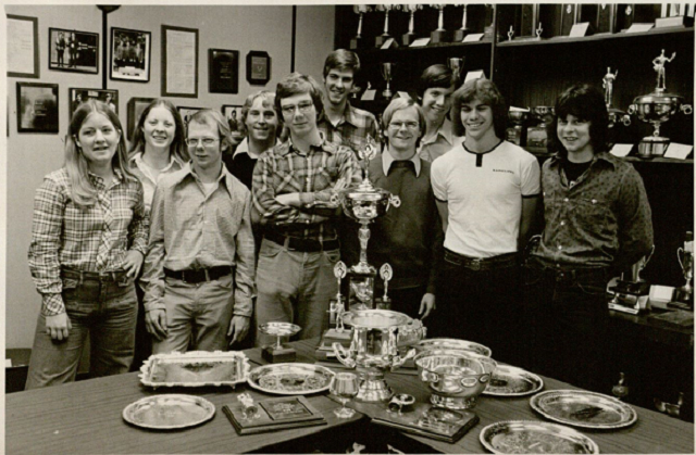 the team smiling with trophies in front of them