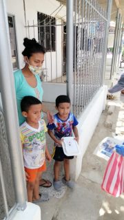 a woman standing with two children on a porch