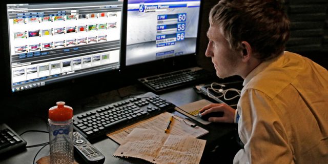 Carson studies images of weather maps and forecast temperatures on two computer screens.