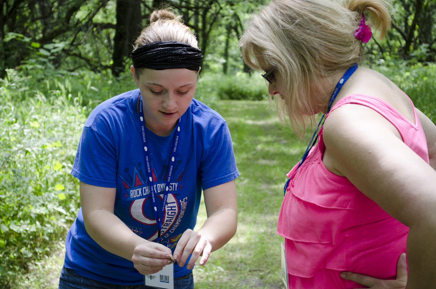 Two people look at a cicada