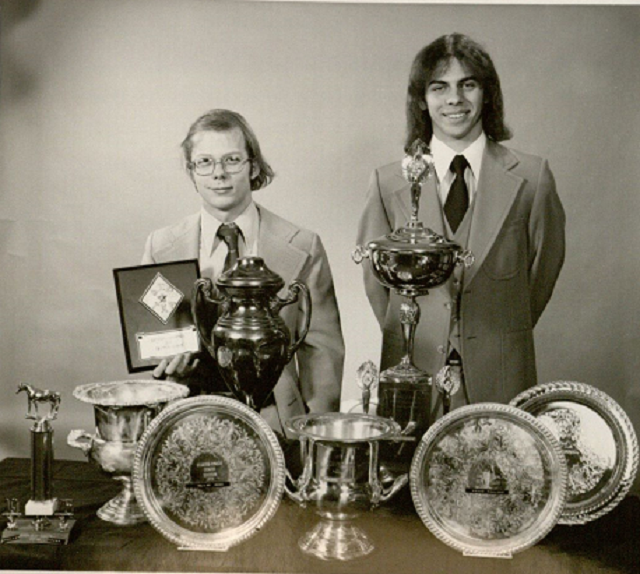 two smiling students in suits