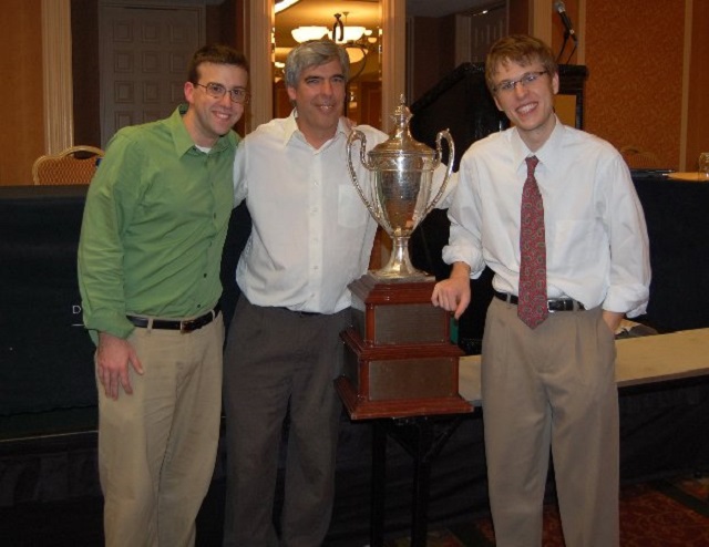 the debate champions and coach with their trophy