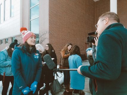 Two people talking outside of the caucus on a cold day