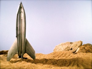 Model space shuttle placed on a sandy ground