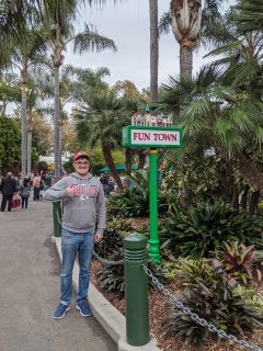 Alex posing in front of a 'Funtown' sign