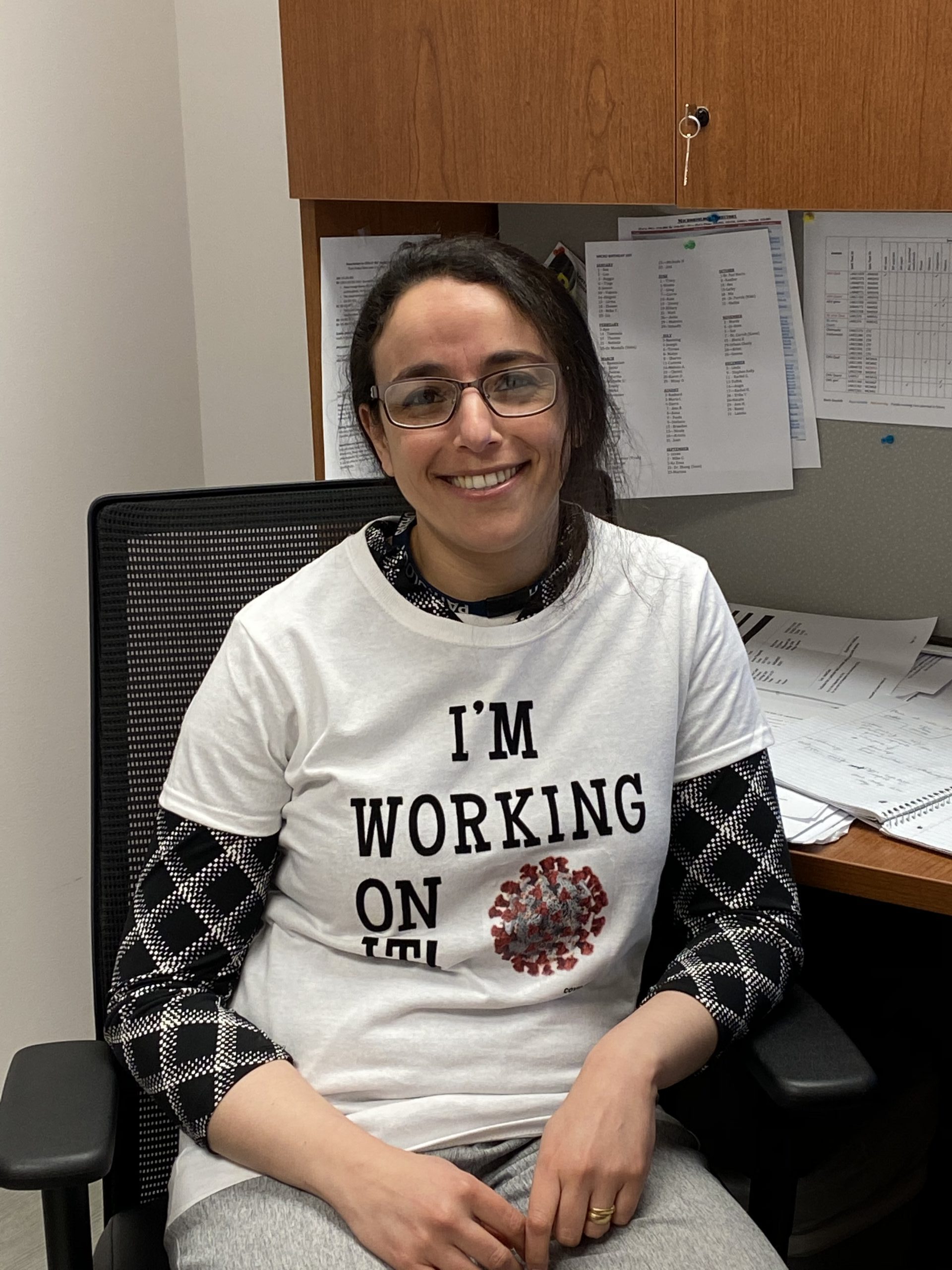 Heba Mostafa wearing a shirt with the Covid virus on it and the text 'I'm working on it!'