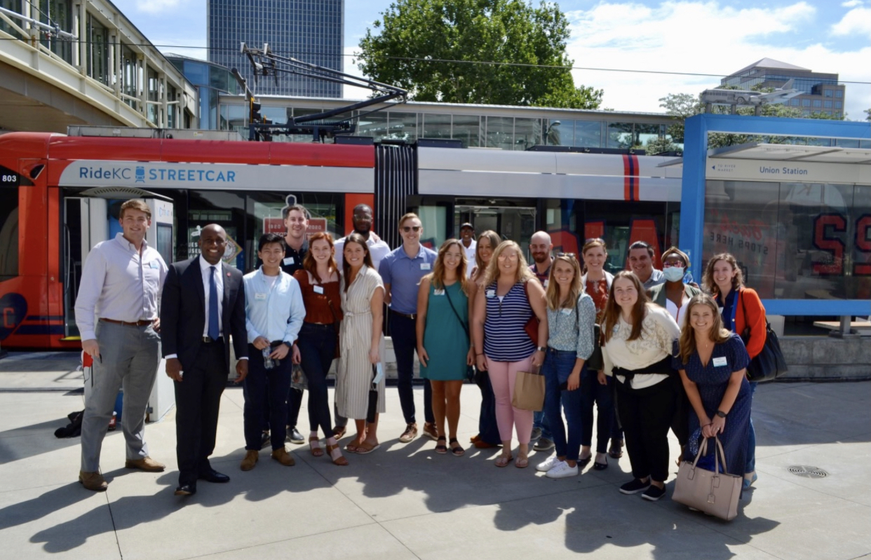 Madeline in a group of people in downtown KC taking a picture next to a streetcar