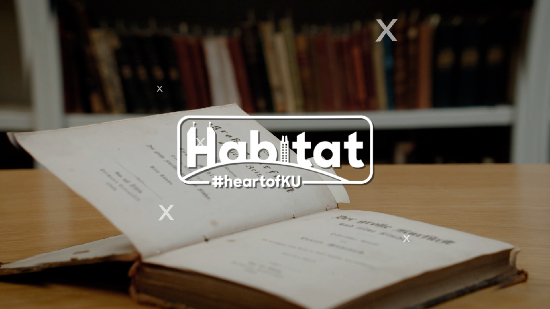 Habitat logo overlaying open book on table