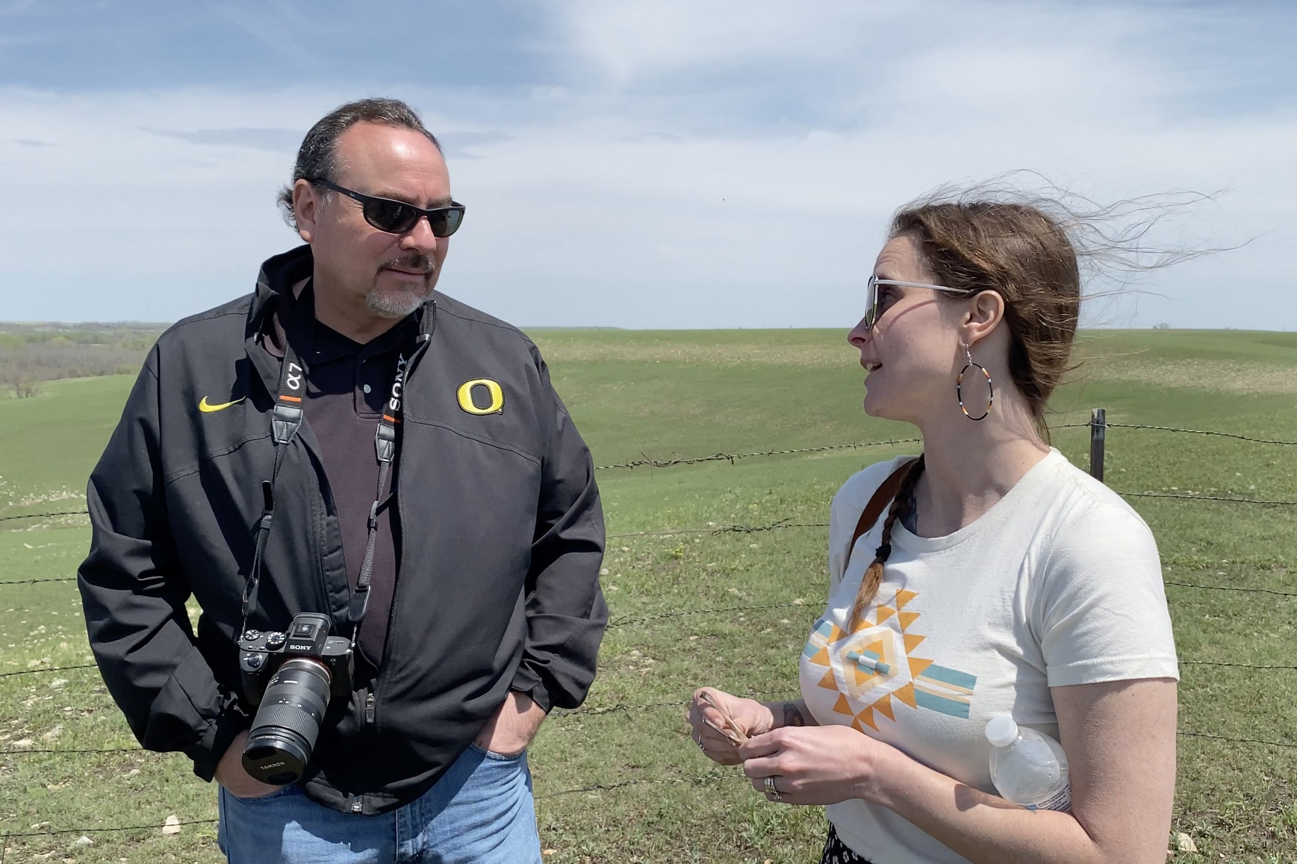 Sydney Pursel speaks to a man in a field