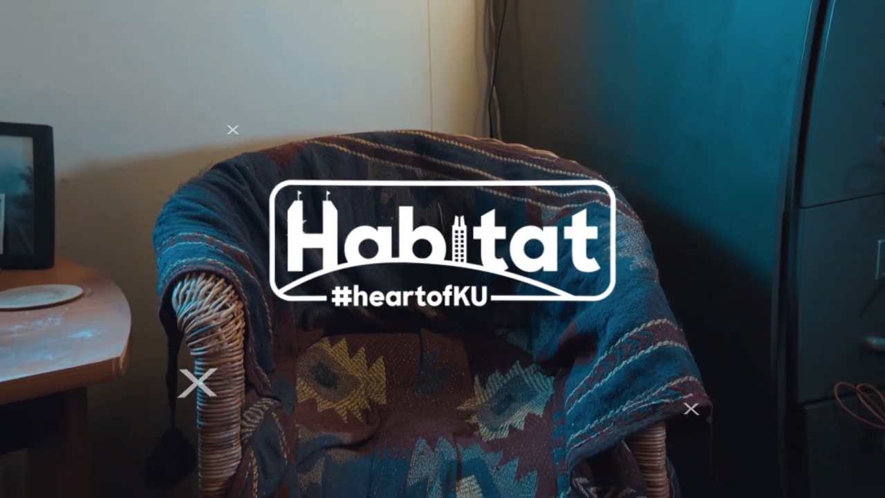 Habitat logo over blanket draped on a wicker chair