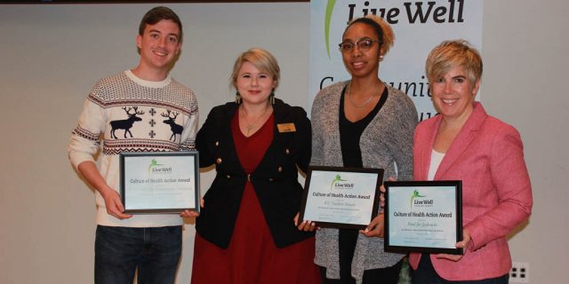 People posing for photos with their certificates