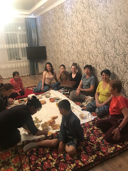 A group of people seated on the floor for a meal