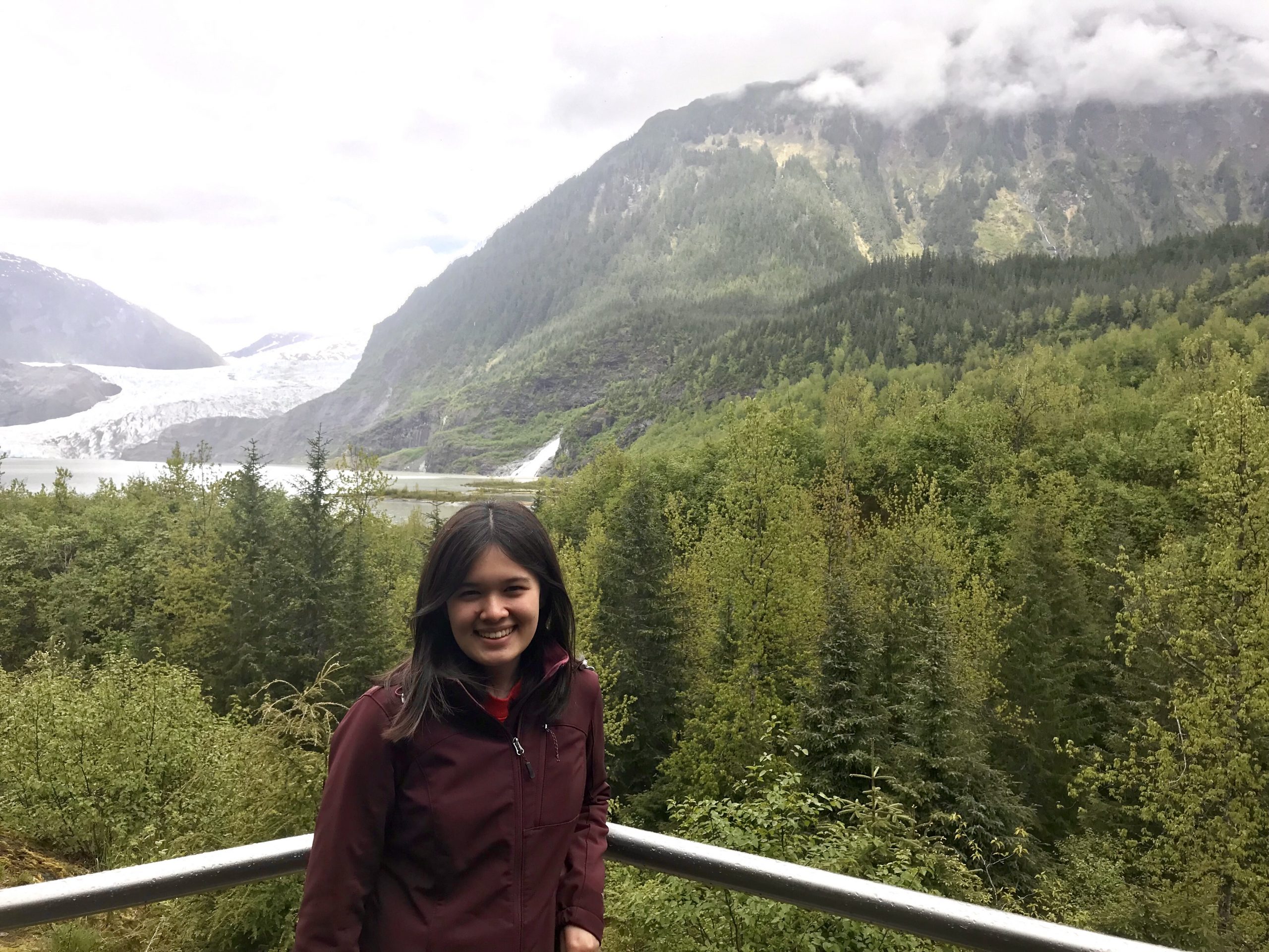 Myra Dotzel on a porch with a forest and mountains in the background