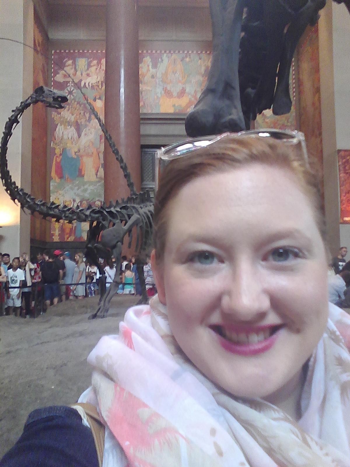 Brittney Oleniacz selfie in front dinosaur exhibit