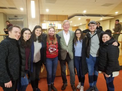 a group of people with their arms around one another smiling