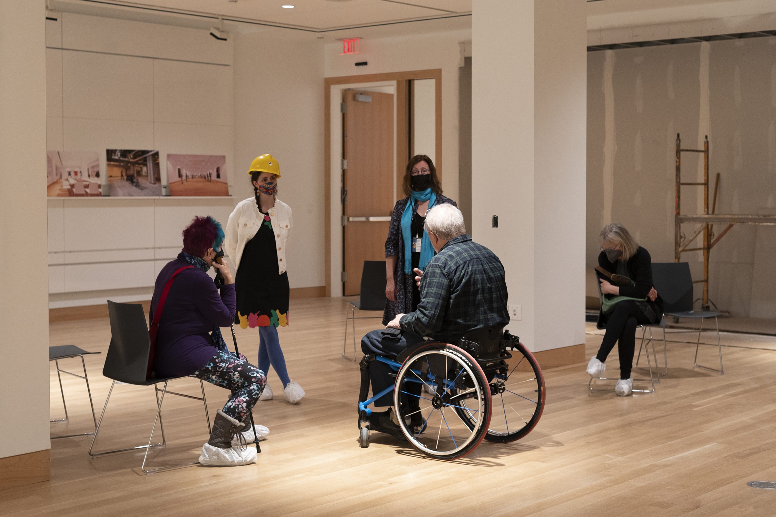 Sydney Pursel speaks to a small group of people in a gallery