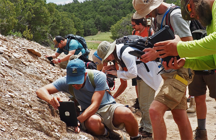 A groupd of geologists looking at a hillside