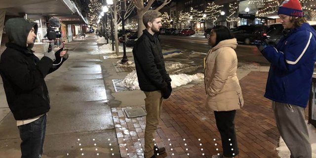 students shooting a film in downtown Lawrence on Mass street