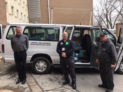 three people stand in front of a van