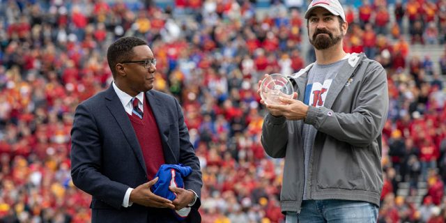 Rob Riggle holding up an award he just received