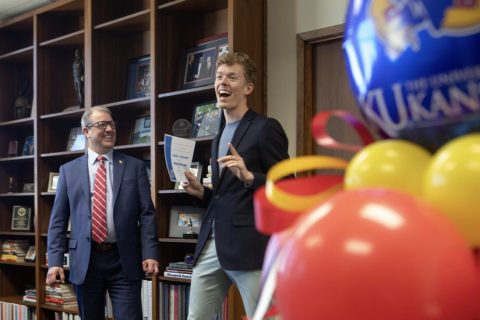 An excited Sam Steuart receives an award from Chancellor Girod