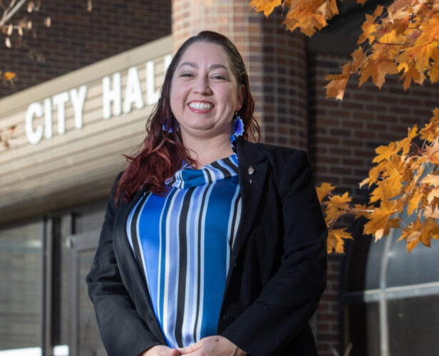 Courtney Shipley, pictured outside City Hall wearing a blue and black striped shirt and black jacket. 