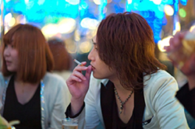 a person with long hair smoking a cigarette