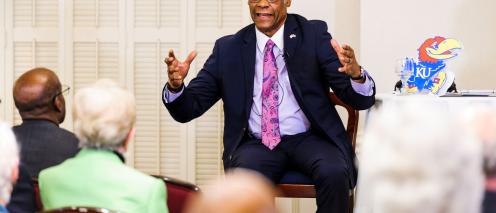 Delano Lewis speaks to a room of people
